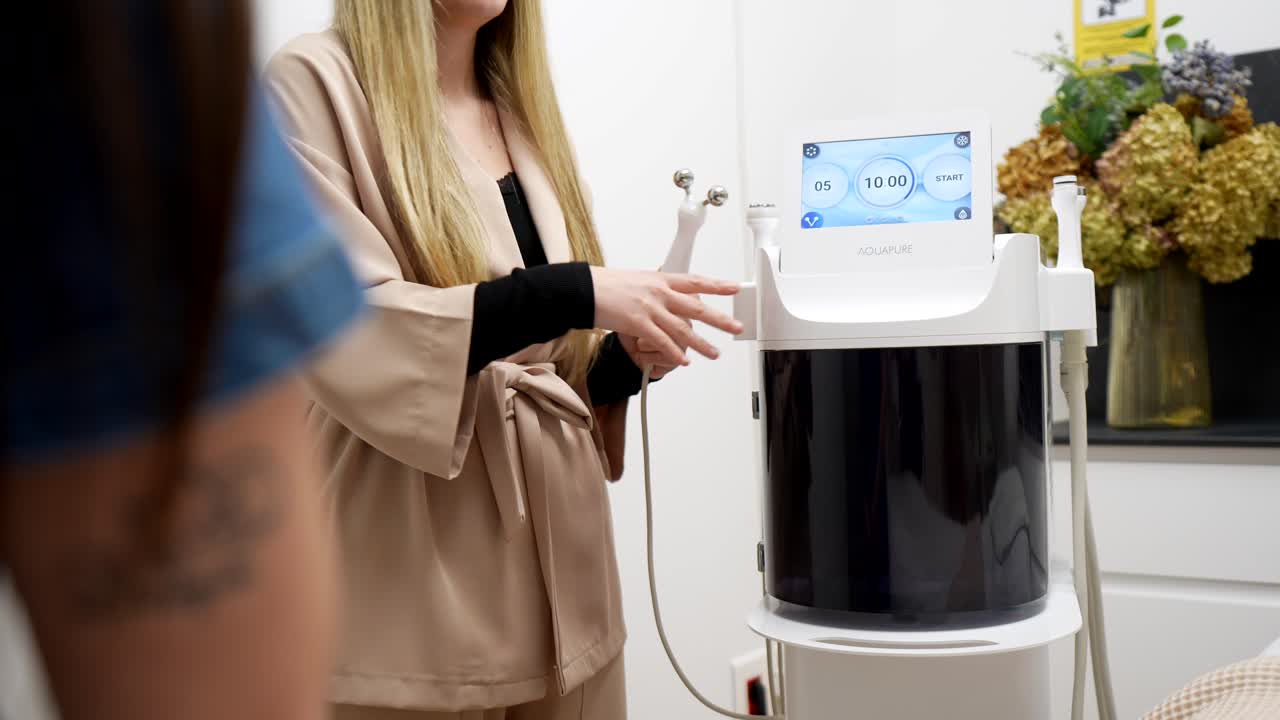 Женщина-косметолог подготавливает аппарат для ухода за кожей Aquapure