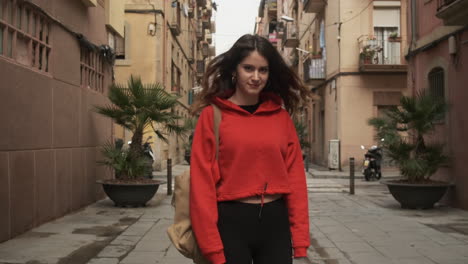 joven sonriendo a la cámara mientras camina por la calle