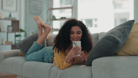 Smile,-sofa-and-woman-typing-on-a-phone-for-text