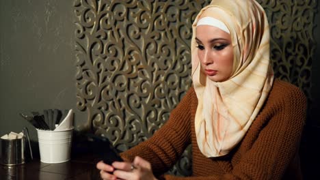 woman in a cafe using a smartphone