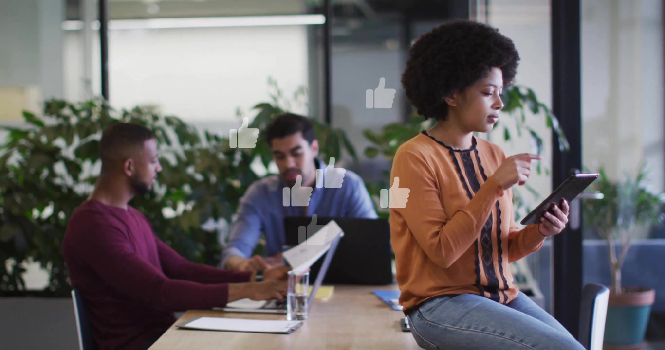 woman tapping tablet triggers floating thumbs up icons around colleagues in social media marketing