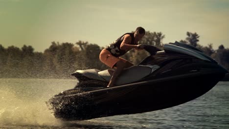 active man riding jet ski at sunny day. rider jumping on jet ski on waves