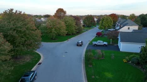 Car-driving-through-upscale-American-neighborhood-during-autumn