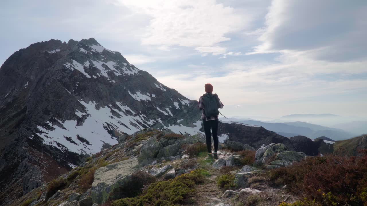 Female hiker enjoying the view of mountain peak in spain on a sunny day. Steady shot