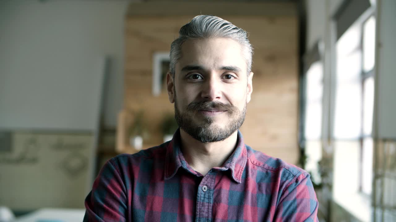 vista frontal de un joven sonriente y alegre con cabello gris