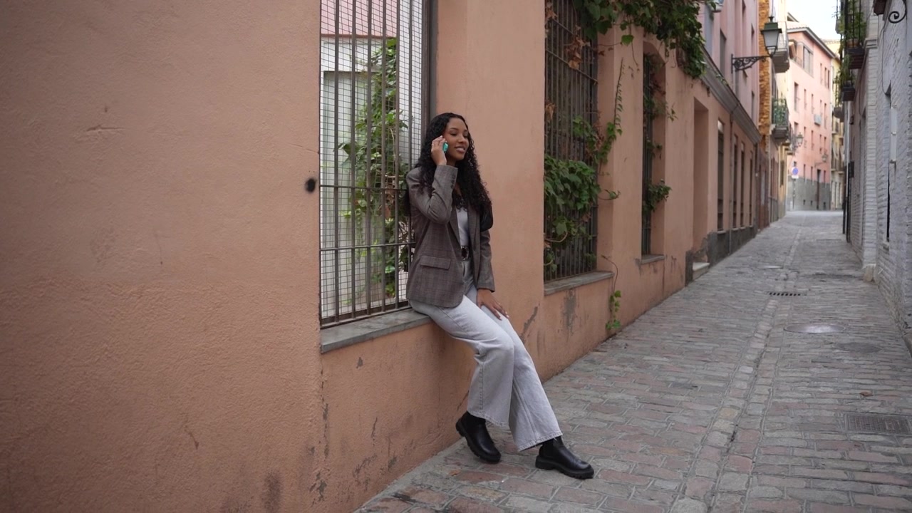 Passeggiata in un vicolo affascinante: una giovane donna, vestita con un outfit trendy ed elegante, fa una passeggiata.