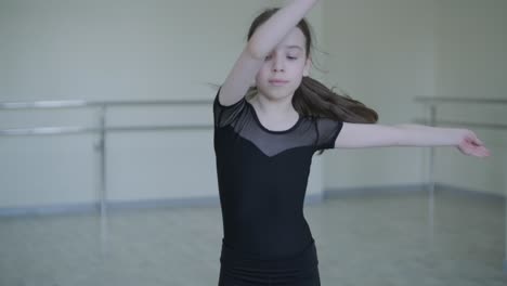 young ballerina practicing dance moves in studio