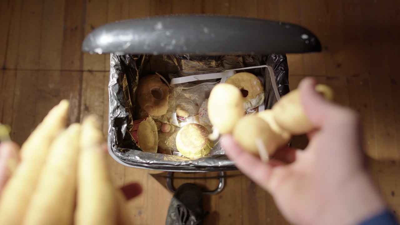 residuos de alimentos vegetales orgánicos desechados en el contenedor de basura, manos pov disparado