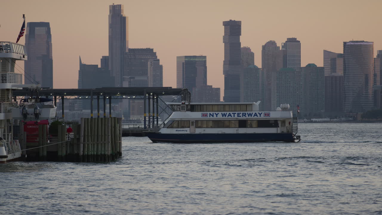 New York Waterway Ferry Coming Into Harbour Pier During Golden Hour With New York Skyline In The Background. Slow Motion, Locked Off