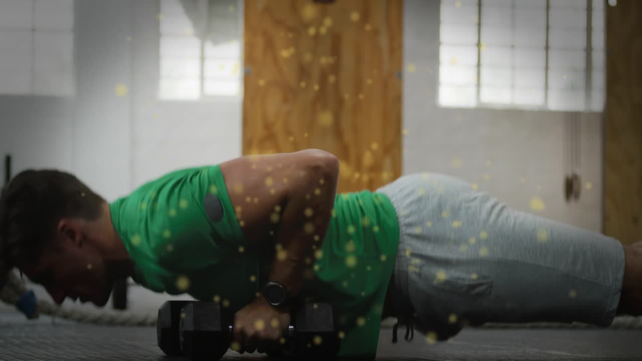 Mand i planke, starter en armbøjning på gulvet, udfører skiftende håndvægtsræk for fitness.