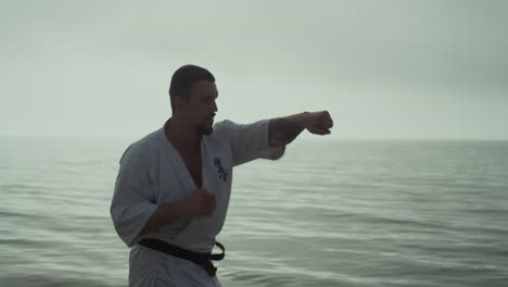 un luchador de karate haciendo golpes dinámicos con las manos al atardecer. un hombre practicando la lucha.