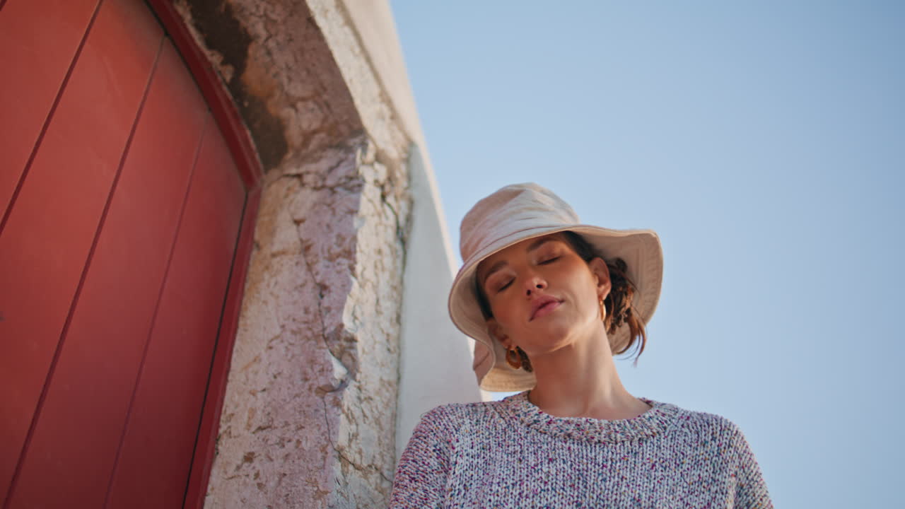 클로즈업 캐주얼 여성은 오래된 도시를 여행합니다. 아름다운 무모한 소녀는 카메라를 찾고 있습니다.