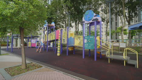 reveal behind tree to empty colorful global playground gym set with no children in down town