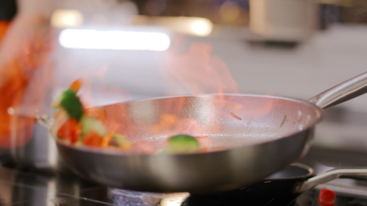 Primo Piano di Verdure Fiammeggiate con Fiamma in Padella da Cucina Professionale