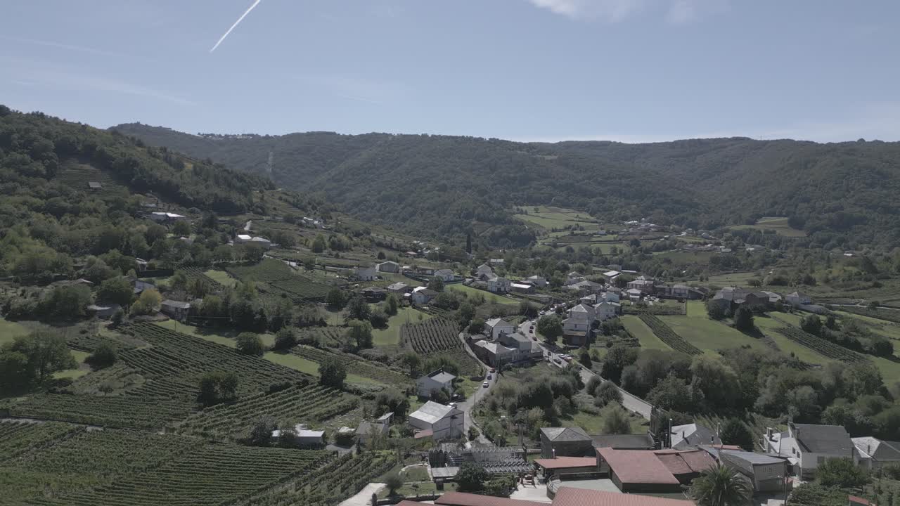 pueblo de montaña en un día soleado con campos verdes y bosque, abeleda, españa