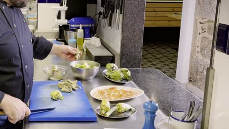 preparación de alcachofas, cortando las alcachofas en cocina profesional.