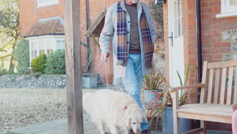 grandparents with granddaughter and pet dog outside house getting ready to go for winter walk