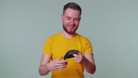 young smiling man happily taking off medical mask and throws it away celebrating coronavirus end