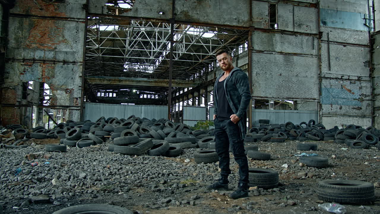 Man standing in ruined building. Young man posing in abandoned building