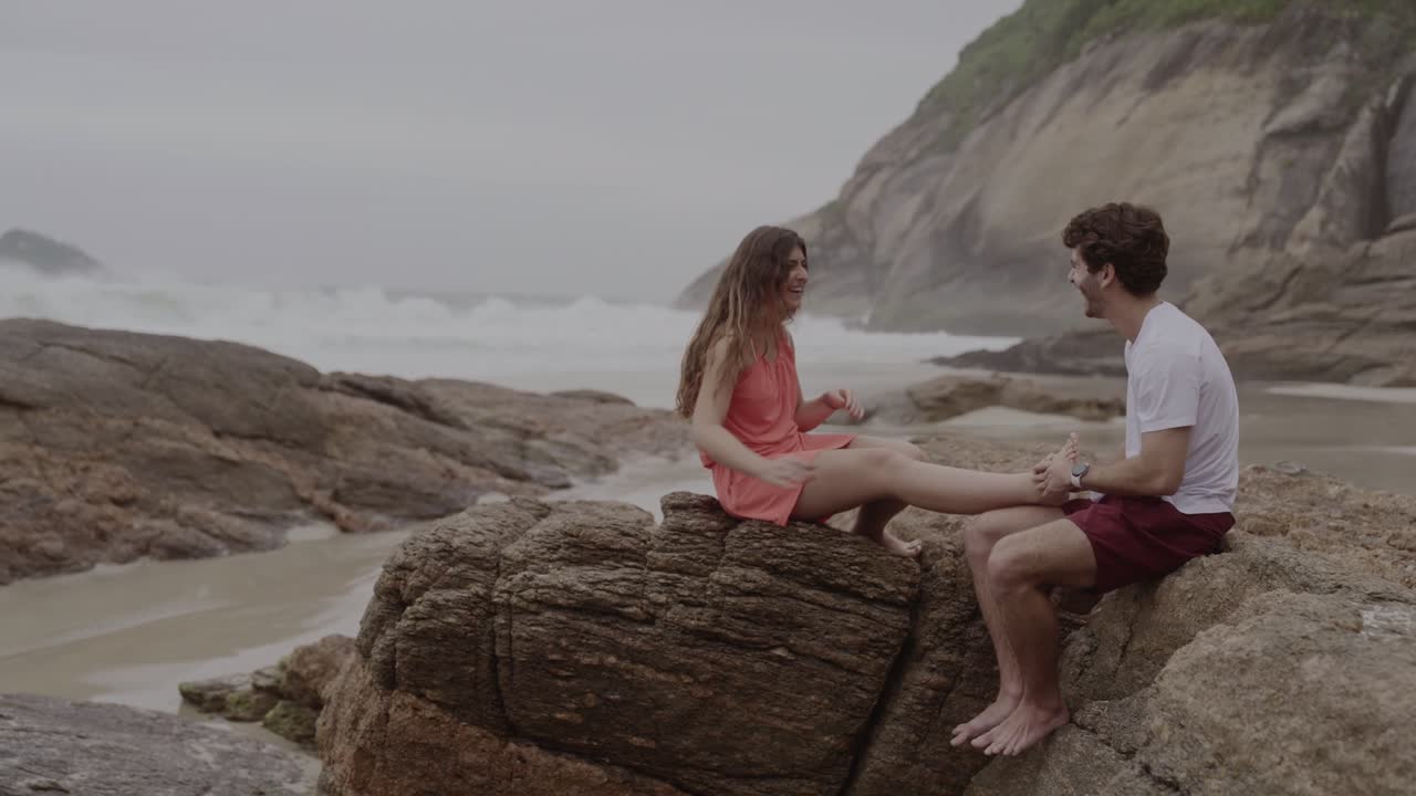 Couple Playfully Interacting on a Rocky Beach