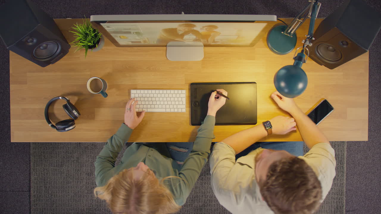 vista aérea de diseñadores gráficos masculinos y femeninos trabajando en la pantalla de la computadora en una oficina creativa