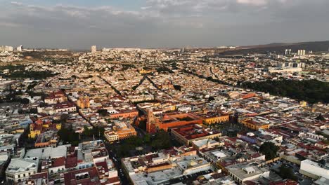 Panoramic-drone-shot-around-the-old-town-of-Queretaro-city,-sunset-in-Mexico