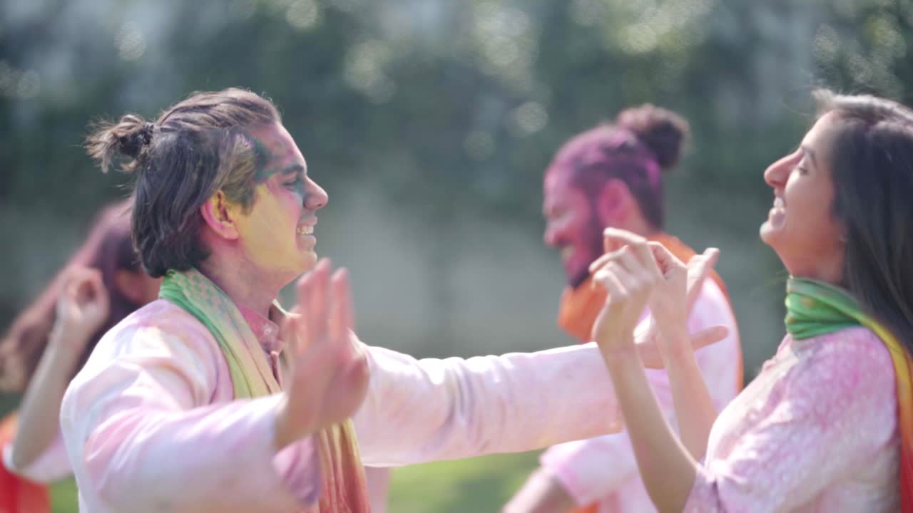Coppia indiana che balla a una festa Holi in un parco.