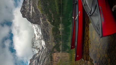 lapso de tiempo vertical 4k, barcos amarrados, muelle y nubes moviéndose sobre picos y lago o'hara, parque nacional yoho, canadá