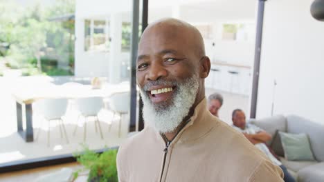 Portrait-of-happy-senior-african-american-man-with-other-seniors-at-retirement-home