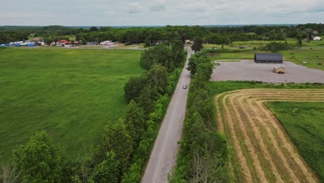 asphalt road near agricultural land and rural town