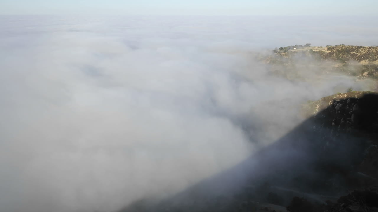 몬테시토 캘리포니아 위의 산타 이네즈 산맥을 따라 일출 시 해안 안개의 근접 촬영 시간 경과