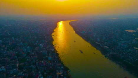 Vista-Aérea-Por-Drones-Del-Río-Buriganga-Que-Divide-La-Ciudad-De-Dhaka-Por-La-Mitad-Durante-La-Hora-Dorada,-Bangladesh