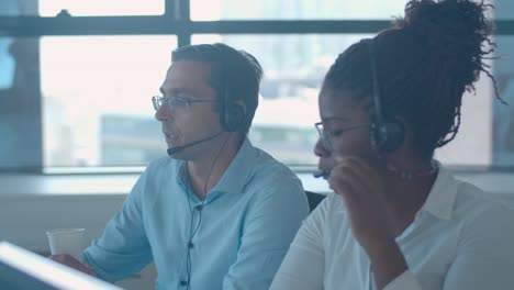 diverse call center employees in headsets discussing call