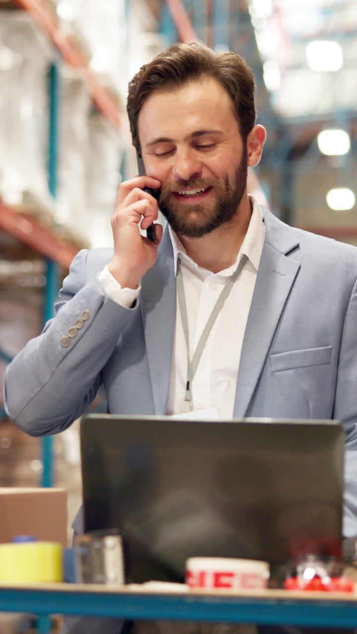 Hombre usando un teléfono y un portátil en un almacén