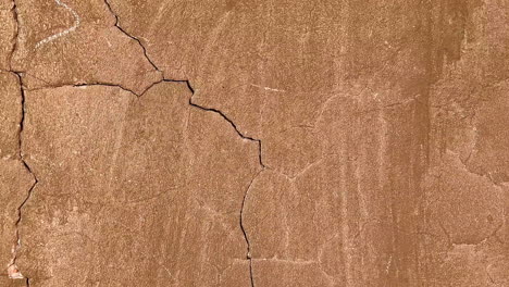 close-up of cracked and weathered concrete wall with hole and rough surface background