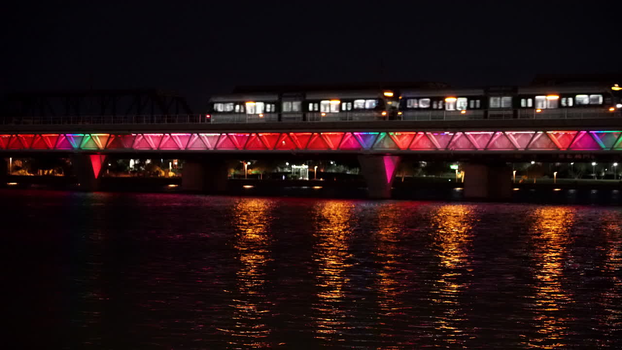 tranvía sobre el puente de agua por la noche con luces coloridas