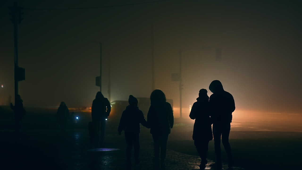 People walking in foggy city night