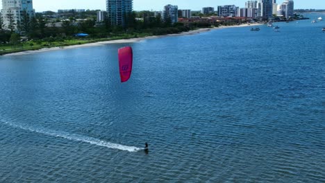 Windsurfing-enjoying-solitude-on-the-glorius-Gold-Coasts-water-ways,-Behind-are-Luxury-Apartments