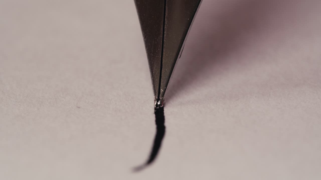 Fountain Pen Nib Drawing a Black Line on White Paper