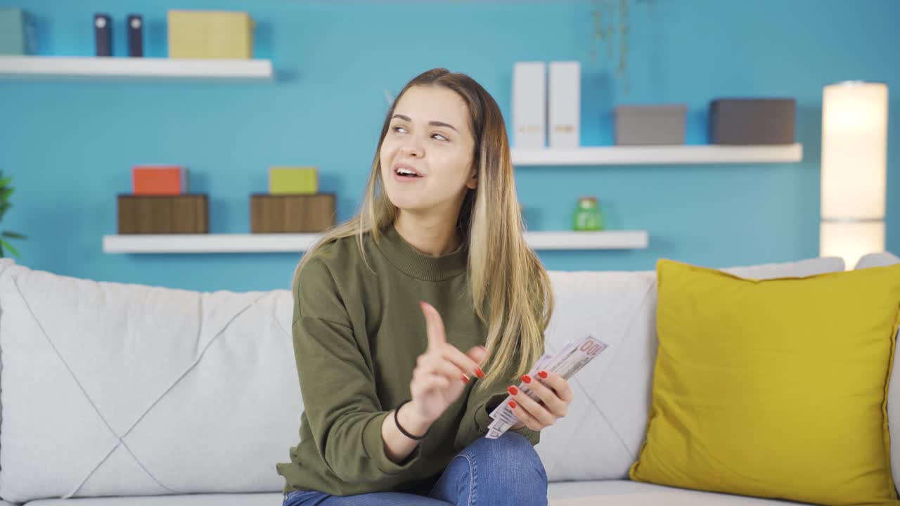 쾌활한 젊은 소녀가 돈을 세고 있습니다.