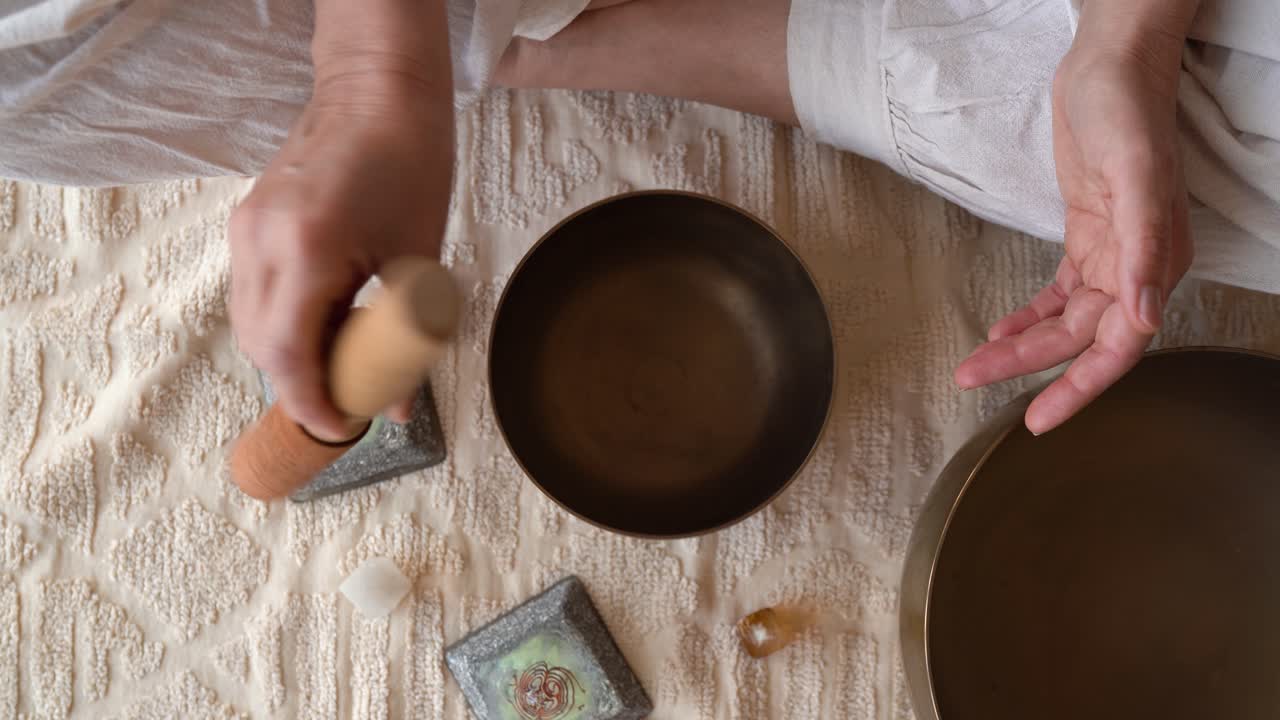 Sound Therapy Practice. Person With A Wooden Mallet Striking A Tibetan Bowl. High Angle Shot