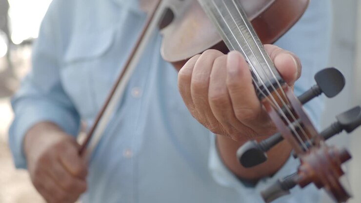 Primo piano delle mani di un uomo che suona il violino