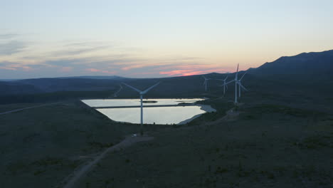wind farm at sunset in mountainous landscape