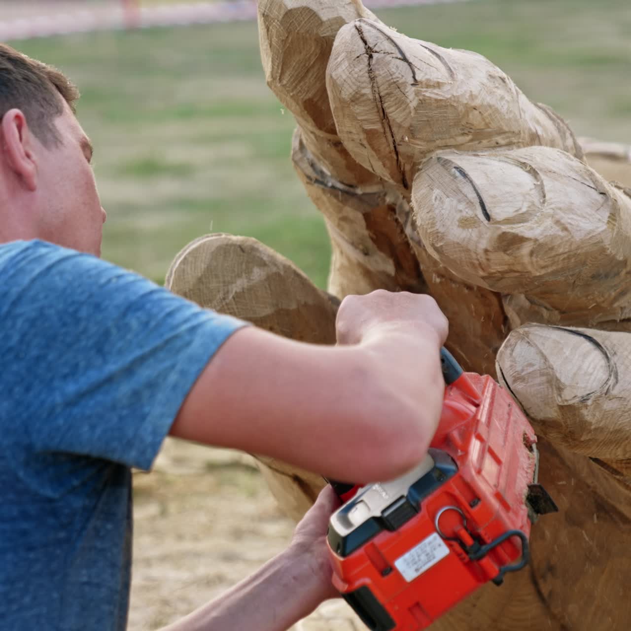 Chainsaw art creating handsome man. Wooden sculpture making