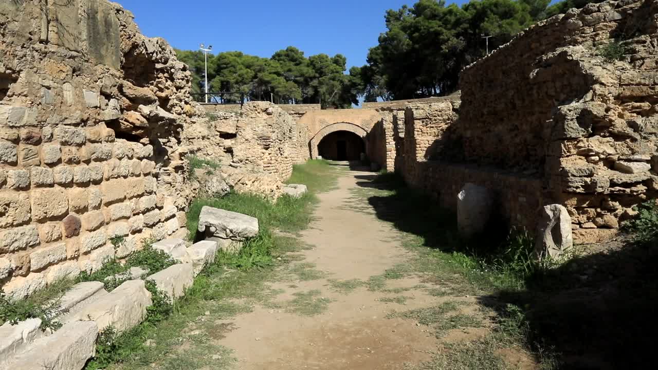 un día soleado en las antiguas ruinas romanas en cartago, túnez, con un cielo azul claro y arcos históricos.