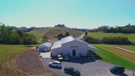 aerial passing over barn to reveal rural countryside homes and highway, 4k