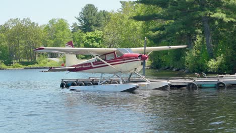 un hidroavión rojo atracado en un lago