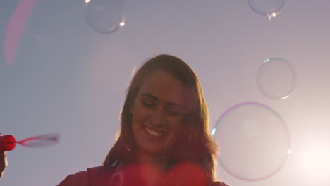 beautiful-young-caucasian-woman-blowing-bubbles-on-rooftop-at-sunset-enjoying-playful-summer-day-outdoors-with-sunshine-flare