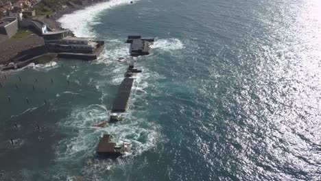 vista aérea de la destrucción de las olas en el puerto deportivo desactivado de lugar de baixo, ponta do sol, isla de madeira, portugal