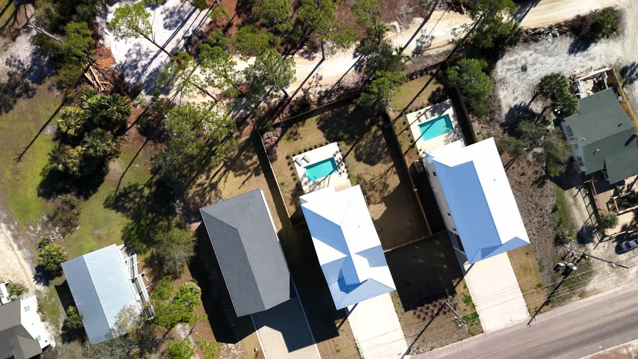 Top-down spiral drone movement from the suburban houses with small backyards and private pools at Panama City Beach, Florida, USA